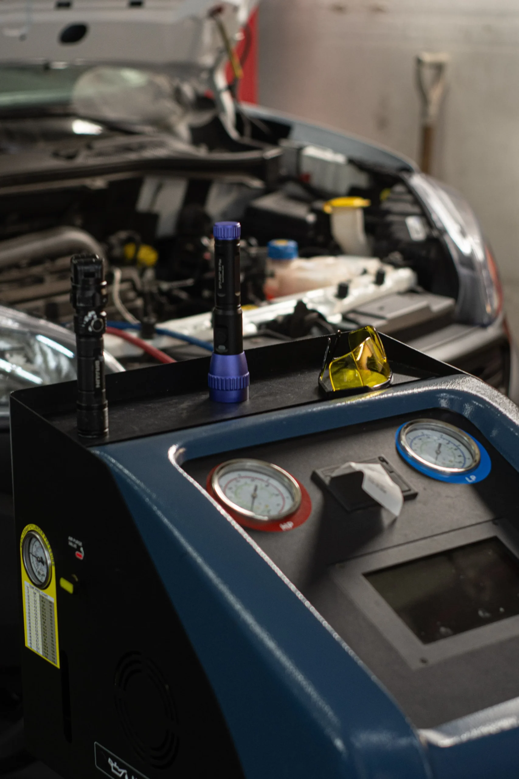 Why Is My Car's AC Not Blowing Cold? 1 Image of Air Conditioning recharge machine connected to vehicle.